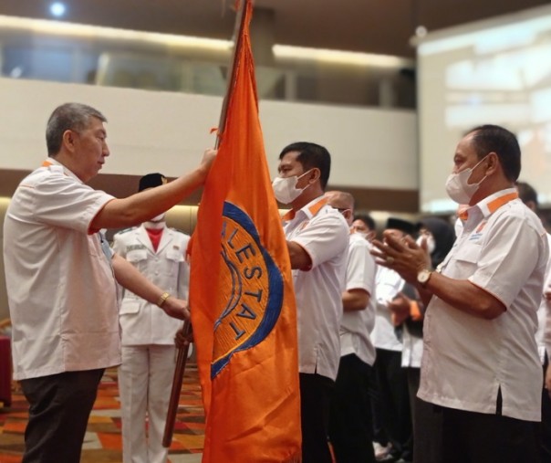 Ketua Umum REI Paulus Totok Lusida (kiri) saat menyerahkan pataka bendera REI kepada Ketua DPD REI Riau Periode 2021-2024 Elvi Syofriadi alias Anton di Hotel Premiere Pekanbaru, Kamis (8/4/2021). Foto: Surya/Riau1.