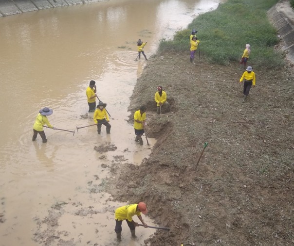 Pasukan kuning  Dinas PUPR Pekanbaru saat membersihkan endapan lumpur di Sungai Sail. Foto: Surya/Riau1.