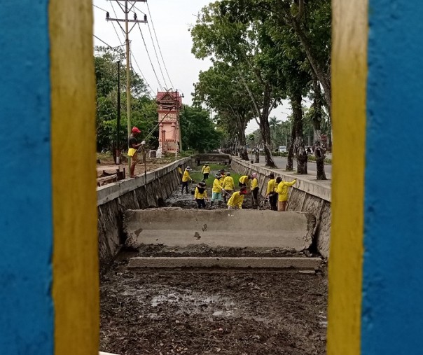 Pasukan kuning Dinas PUPR Pekanbaru saat membersihkan saluran drainase di Kawasan Purna MTQ. Foto: Surya/Riau1.