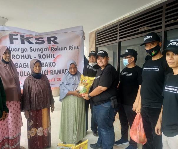 Ketua FKSR Riau Romi Auni menyerahkan bantuan sembako kepada warga Rohul dan Rohil tak mampu di Kelurahan Sialang Sakti, Kecamatan Tenayan Raya, Pekanbaru, Minggu (11/4/2021). Foto: Istimewa. 