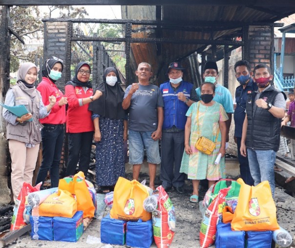 Kepala Dinsos Kota Pekanbaru Mahyuddin (rompi biru) dan bawahannya menyalurkan bantuan kepada korban kebakaran di Tanjung Rhu, Minggu (11/4/2021). Foto: Istimewa.
