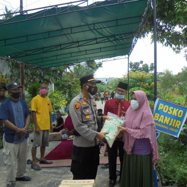 AKP Arry Prasetyo menyerahkan bantuan kepada warga yang mengungsi akibat banjir di Tangkerang Labuai.