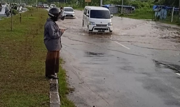 Sejumlah kendaraan menerobos genangan air di Jalan Sembilan, Rumbai  