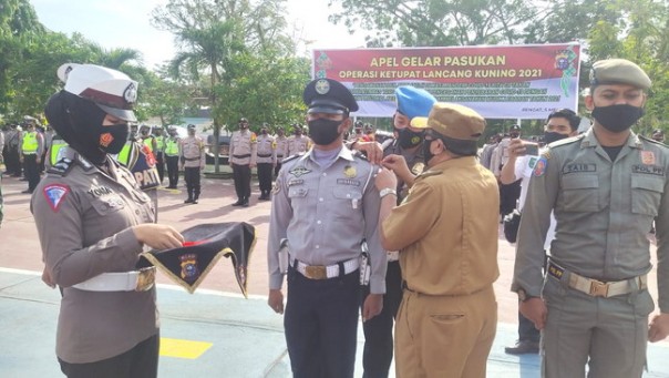 Penjabat Bupati Inhu Pasangkan pita pada Apel Gelar Pasukan Ops Ketupat Lancang Kuning