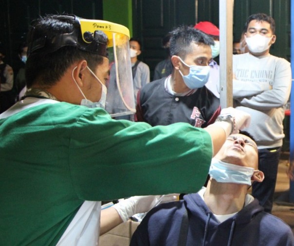 Petugas medis saat melakukan swab antigen terhadap pengunjung di salah satu warung Jalan Jenderal Sudirman, Selasa (1/6/2021). Foto: Satpol PP Pekanbaru. 