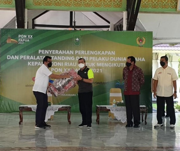 Senior Executive Vice President Business Support PTPN V Rurianto menyerahkan secara simbolis bantuan untuk kontingen Riau yang berlaga di PON Papua XX kepada Gubernur Riau Syamsuar. Foto: PTPN V. 
