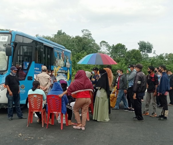 Kerumunan warga yang antre di samping bus vaksinasi keliling di halaman parkir Kompleks Perkantoran Tenayan Raya, Senin (21/6/2021). Foto: Surya/Riau1.