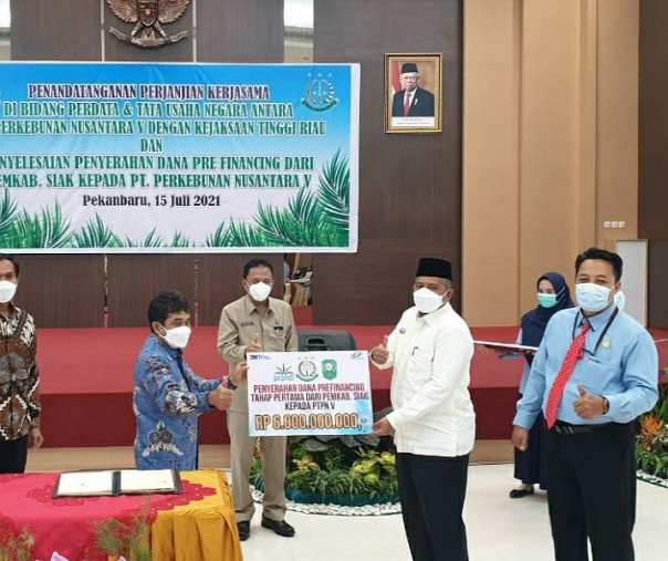 Bupati Siak Alfedri (kemeja putih) menyerahkan secara simbolis pembayaran utang senilai Rp6 miliar kepada PTPN V yang diwakili SEVP Operation Ospin Sembiring di Aula Kejati Riau, Kamis (15/7/2021). Foto: Istimewa. 