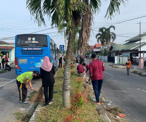 Mahasiswa Kukerta UNRI mengikuti kegiatan gotong royong bersama Kepala Desa Jaya Firdaus Roza dan jajarannya, Jumat (16/7/2021). Foto: Istimewa.