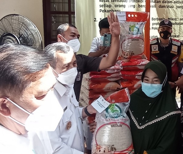 Gubri Syamsuar didampingi Wali Kota Pekanbaru Firdaus saat menyalurkan bantuan beras kepada warga di halaman Kantor Kelurahan Labuhbaru Barat, Kecamatan Payung Sekaki, Rabu (21/7/2021). Foto: Surya/Riau1.