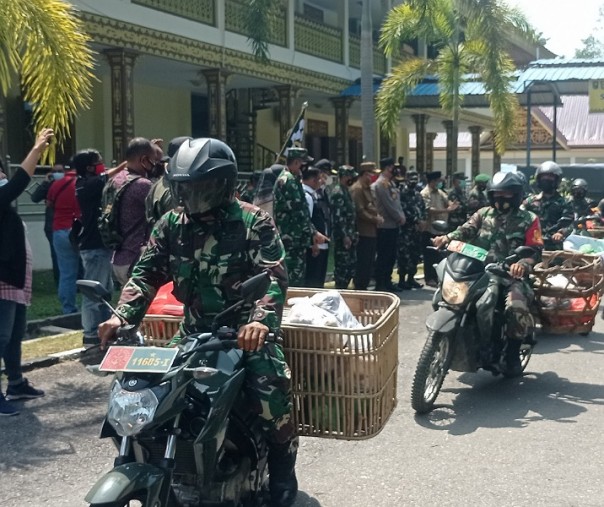 Para Babinsa mengantarkan nasi bungkus dari dapur umum di halaman Gedung LAM Riau, Rabu (28/7/2021). Foto: Surya/Riau1.