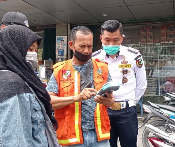 Petugas Dishub Pekanbaru mengajarkan juru parkir cara menggunakan alat pembayaran parkir. Foto: Surya/Riau1.