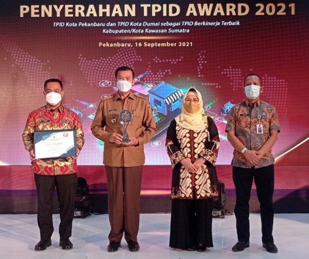 Wali Kota Pekanbaru Firdaus memegang penghargaan TPID Award 2021 didamping Sekda M Jamil (kiri), Asisten 2 El Syabrina, dan pejabat Setdako di Aula BI perwakilan Riau, Kamis (16/9/2021). Foto: Surya/Riau1.
