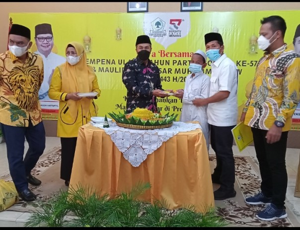 Ketua DPD I Golkar Riau Syamsuar menyerahkan tumpeng pada salah satu anak yatim dalam acara HUT Golkar ke 57 di kantor DPD Golkar Riau jalan Diponegoro, Pekanbaru 