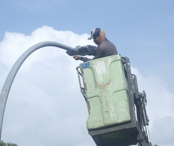 Seorang pekerja sedang mengganti lampu jalan hemat energi Pekanbaru. Foto: Surya/Riau1.