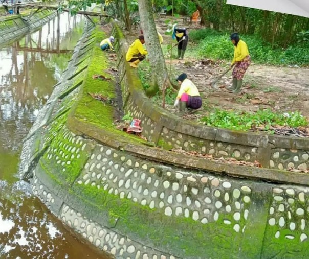 Pasukan kuning Dinas PUPR Pekanbaru saat membersihkan pinggiran drainase di Jalan Datuk Setia Maharaja. Foto: Dinas PUPR. 