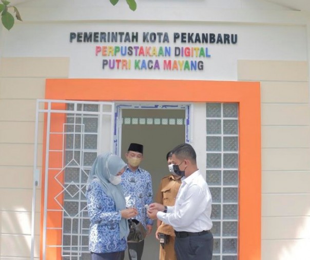 Kepala Bidang P2LP Dispusip Kota Pekanbaru Risna Sari Dewi menerima kunci Perpustakaan Digital Kaca Mayang dari Supervisor Sekretariat dan Umum PT PJB UBJOM) Tenayan Dimas Satriyo Hutomo pada Senin 29 November lalu. Foto: Dispusip. 