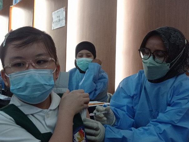 Murid SD Darma Yudha saat disuntik vaksin di Aula SMA Darma Yudha di Jalan Siak 2, Kecamatan Payung Sekaki, Rabu (12/1/2022). Foto: Surya/Riau1.