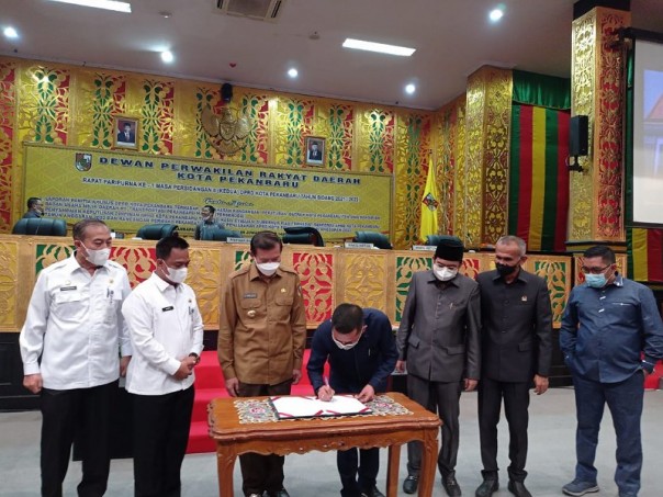 Wali Kota Pekanbaru Firdaus menyaksikan pimpinan DPRD menandatangani dokumen Perda BUMD PT TPM pada 12 Januari 2022. Foto: Istimewa. 