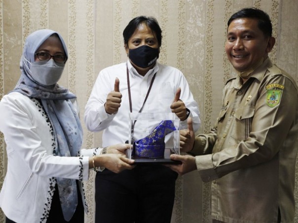 Pihak Kanwil Riau menyerahkan cendera mata kepada Kepala Bapenda Kabupaten Rohil Cicik Mawardi usai penandatangan perjanjian kerja sama pada 31 Januari 2022 lalu. Foto: DJP Riau. 