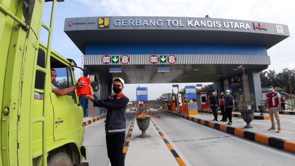 Pengendara yang mendapatkan souvenir di GT Kandis Utara