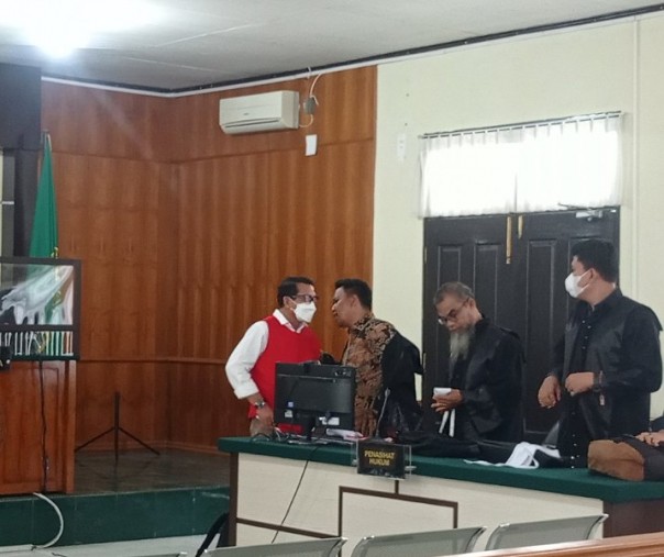Dekan Nonaktif FISIP UNRI Syafri Harto saat berdiskusi dengan salah satu penasihat hukumnya usai dituntut jaksa selama tiga tahun penjara di PN Pekanbaru, Senin (21/3/2022). Foto: Surya/Riau1.