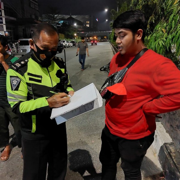 Anggota Satlantas Polresta Pekanbaru meminta keterangan saksi di lokasi kejadian kecelakaan. 