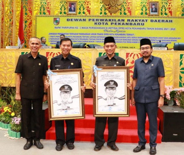 Wali Kota Pekanbaru Firdaus dan Wakil Wali Kota Ayat Cahyadi menerima cendera mata berupa karikatur dari pimpinan DPRD, Kamis (19/5/2022). Foto: Istimewa. 