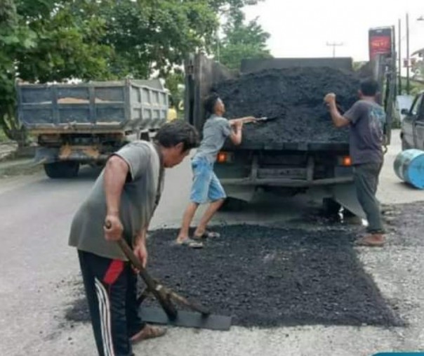Pekerja Dinas PUPR Pekanbaru saat menambal Jalan Parit Indah. Foto: Istimewa.