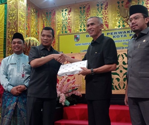 Pj Wali Kota Pekanbaru Muflihun saat menyerahkan Ranperda Pelaksanaan Anggaran 2021 kepada pimpinan sidang paripurna Nofrizal, Senin (20/6/2022). Foto: Surya/Riau1.