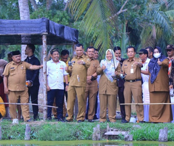 Pj Wali Kota Pekanbaru Muflihun memancing di kolam ikan di sela-sela kunjungan di Kecamatan Rumbai, Selasa (5/7/2022). Foto: Istimewa. 