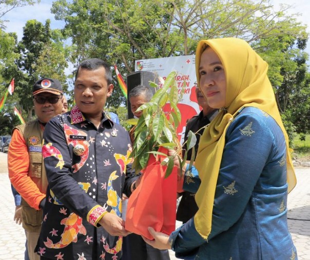 Pj Wali Kota Pekanbaru Muflihun menyerahkan bibit pohon kepada Camat Payung Sekaki Rahmaningsih, Kamis (7/7/2022). Foto: Istimewa. 