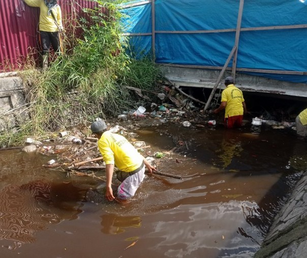Pasukan kuning Dinas PUPR Pekanbaru membesihkan drainase di pertigaan Jalan Arifin Ahmad-Jalan Jenderal Sudirman, Rabu (27/7/2022). Foto: Surya/Riau1.