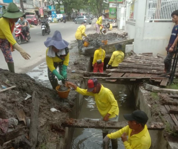 Pasukan kuning Dinas PUPR Pekanbaru membersihkan drainase Jalan Paus. Foto: Istimewa. 