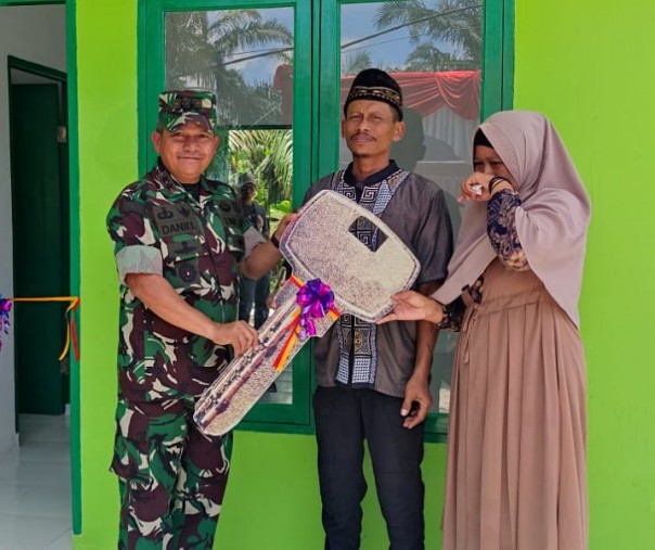 Pangdam I Bukit Barisan Mayjen TNI Achmad Daniel Chardin menyerahkan kunci rumah secara simbolis kepada Prahara dan istri usai direnovasi prajurit TNI dalam program TMMD ke-114 di Kelurahan Sialang Rampai, Kecamatan Kulim, Rabu (24/8/2022). Foto: Istimewa. 