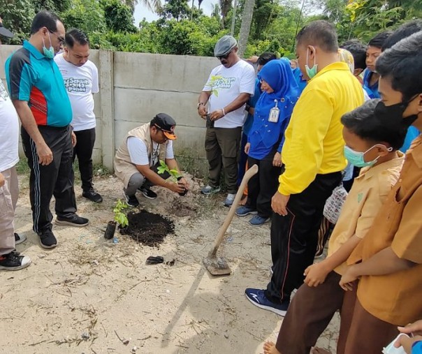 Kalaksa BPBD Pekanbaru Zarman Candra saat menanam bibit pohon Matoa di halaman SMP Negeri 47 pada 1 September 2022. Foto: Istimewa. 