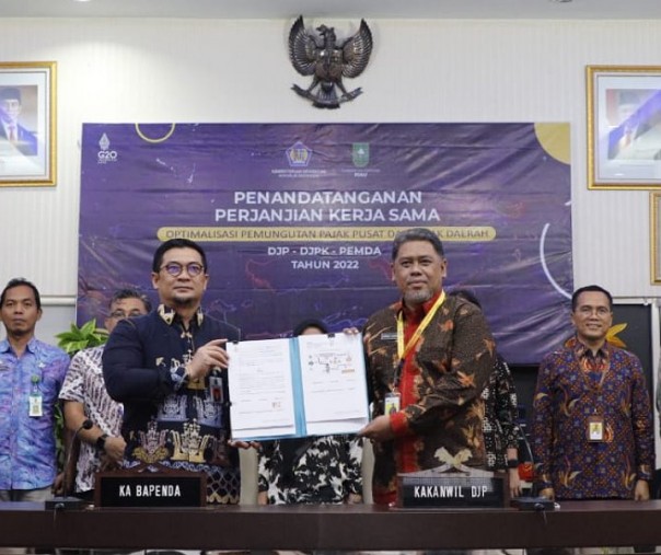 Kepala Kanwil DJP Riau Ahmad Djamhari saat melihatkan dokumen PKS Tripartit yang telah diteken, Kamis (15/9/2022). Foto: Kanwil DJP Riau. 
