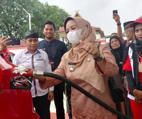 Camat Senapelan Yeni Erita saat mengisikan bensin ke mobil di soft launching SPBU yang sempat tak beroperasi beberapa tahun, Jumat (30/9/2022). Foto: Istimewa. 