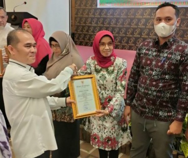 Kepala Diskop dan UKM Pekanbaru Sarbaini menyerahkan penghargaan kepada 15 koperasi terbaik pada 28 September 2022. Foto: Istimewa. 