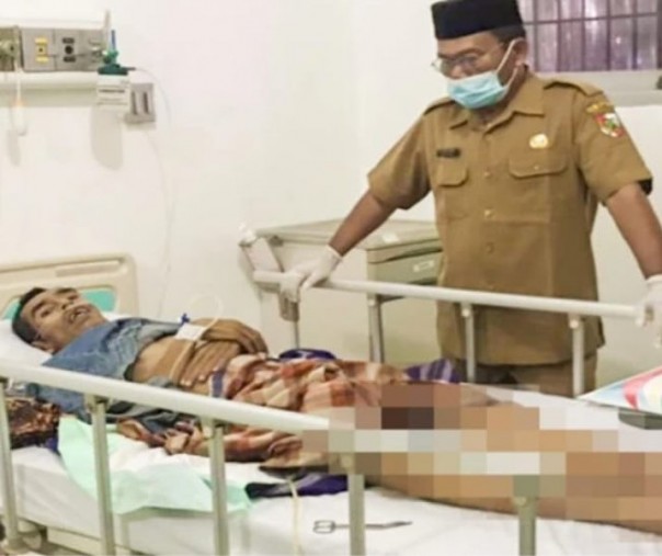 Amir Husin, staf Bidang Perlindungan dan Jaminan Sosial Dinsos Pekanbaru menjenguk orang terlantar menderita tumor ganas di RSUD Arifin Achmad. Foto: Istimewa. 