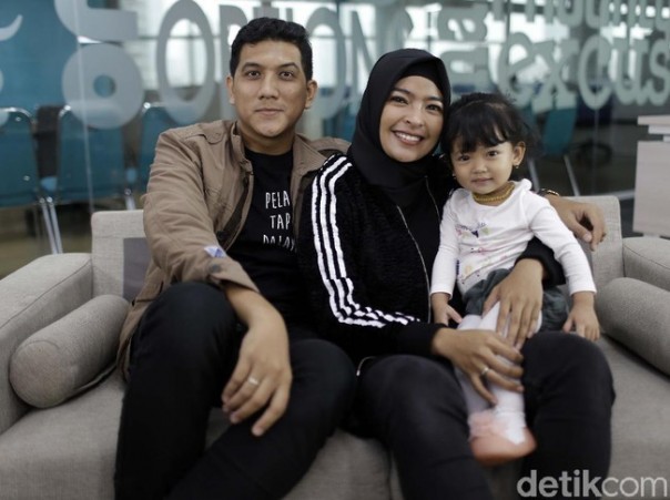 Tantri Kotak yang berhijab bersama suami dan anaknya.