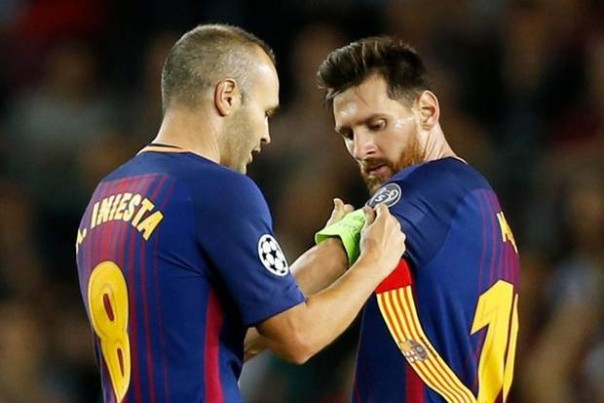 Iniesta menyerahkan ban kapten kepada Lionel Messi saat masih di Barcelona.